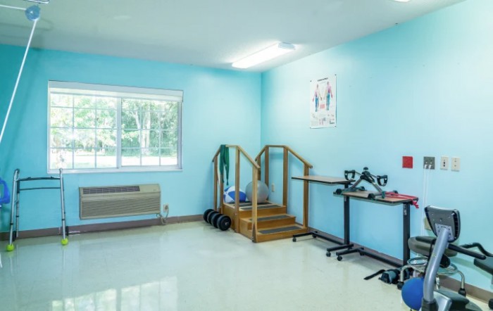 A bright physical therapy room equipped with stairs and various exercise tools.