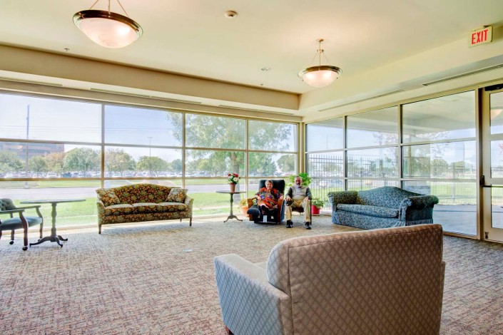 A spacious lobby area with large windows, featuring comfortable seating and ample natural light.