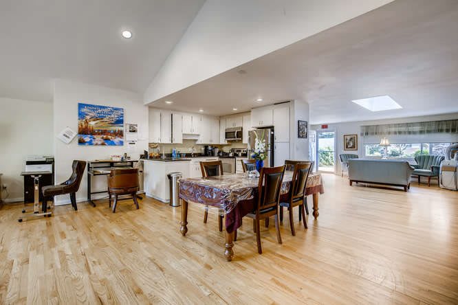 Spacious open-plan dining and kitchen area with modern decor and wood flooring.