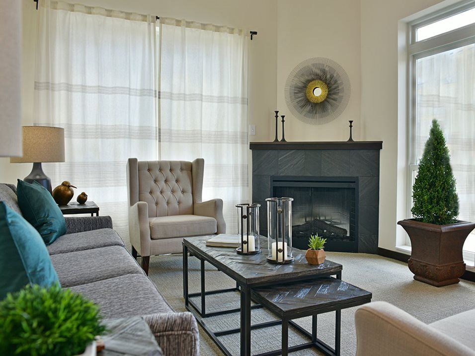 A modern living room featuring elegant furniture, a central coffee table, and a cozy fireplace.