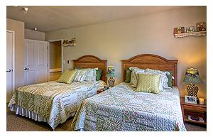 A cozy bedroom featuring two neatly made beds with decorative pillows.