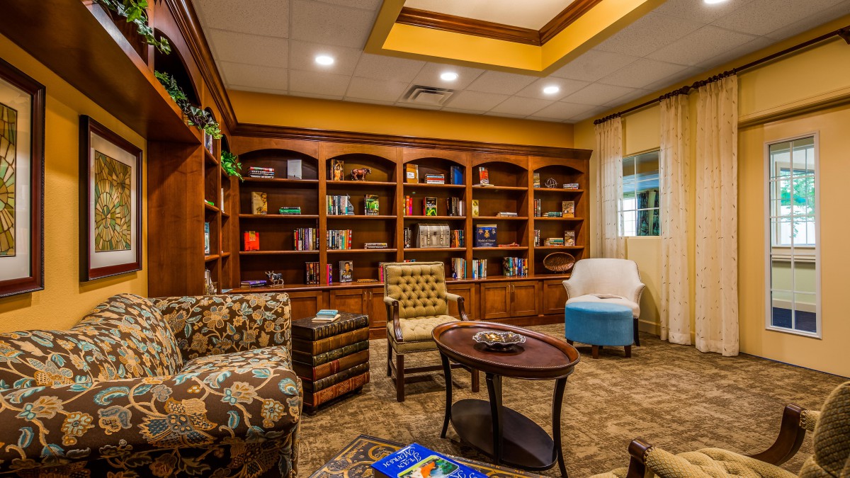 A cozy library room with bookshelves and comfortable seating.