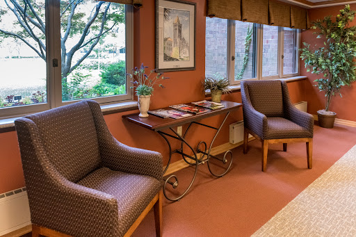 A cozy waiting area with comfortable chairs and a decorative table, featuring a view of the outdoors.