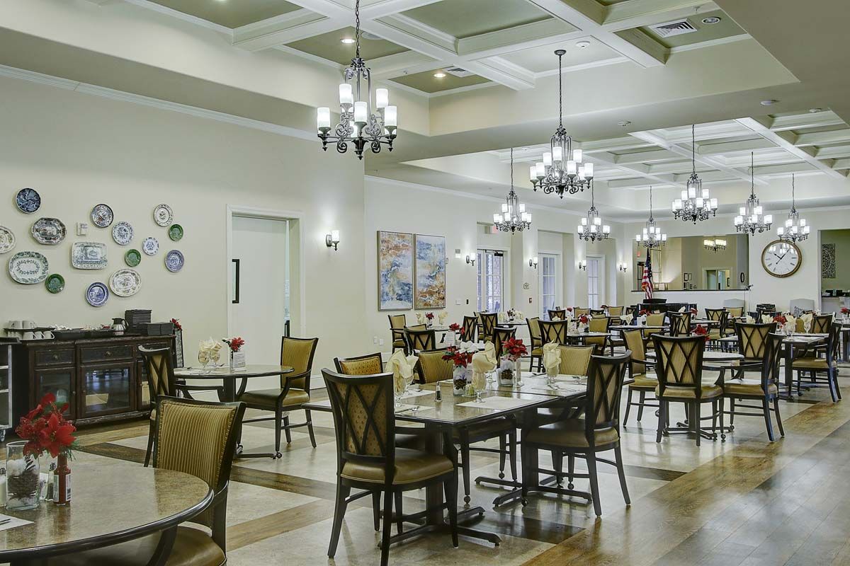 An elegant dining room with chandeliers and neatly arranged tables and chairs.