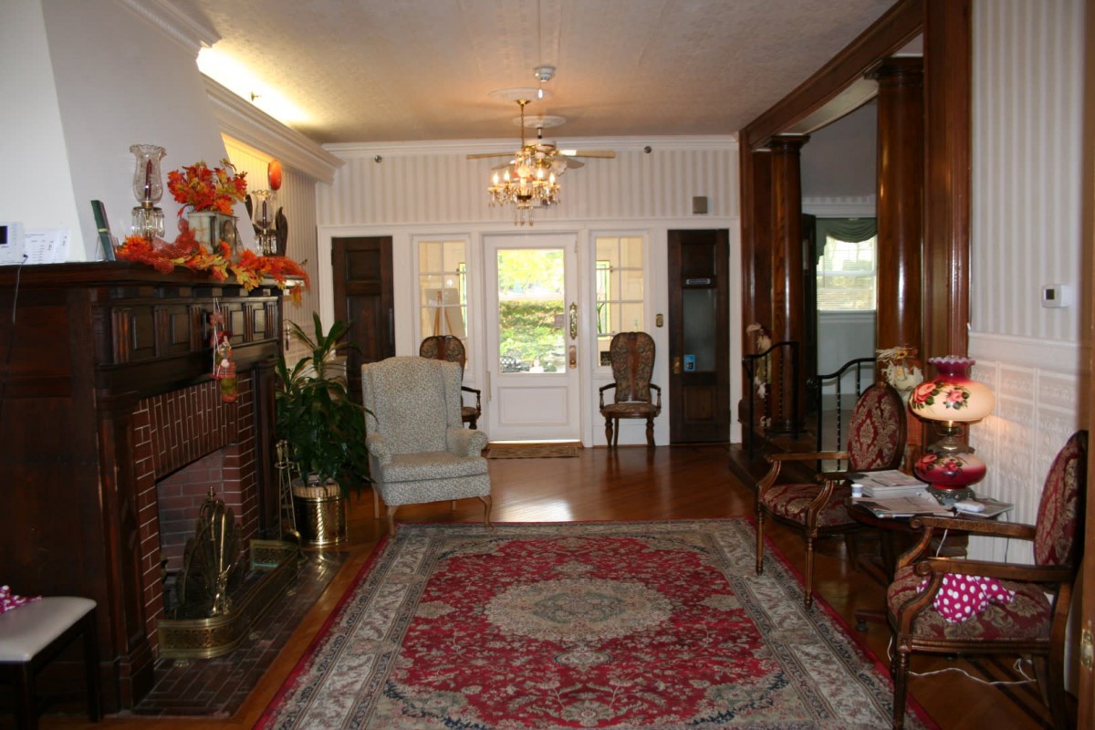 A traditionally decorated living room with a fireplace and chandelier.