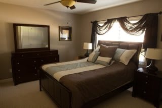 A cozy bedroom with a nicely made bed and elegant decor.