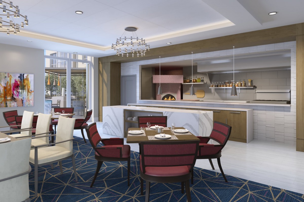 A modern restaurant interior with elegant seating and a visible kitchen featuring a wood-fired oven.
