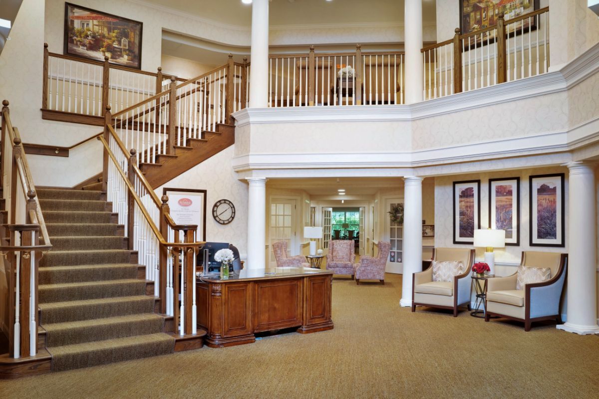 A spacious lobby with a grand staircase, reception desk, and elegant decor.