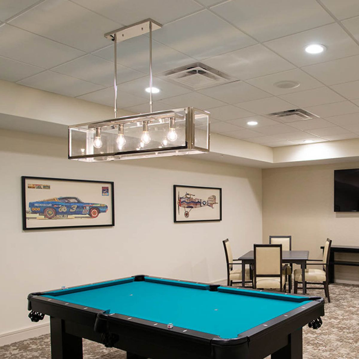 A modern game room featuring a pool table and stylish lighting.