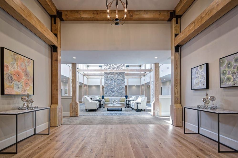 A modern lobby with wooden beams, a chandelier, and a comfortable seating area.