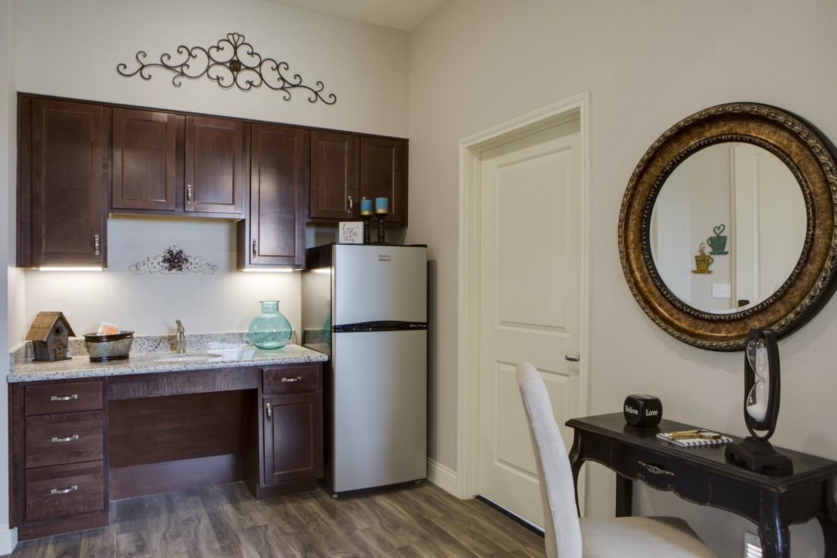 A modern kitchen and dining area with dark wood cabinets and a stainless steel refrigerator.