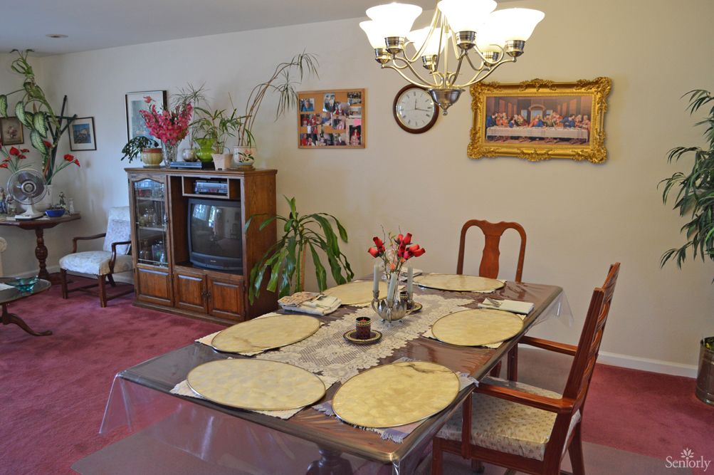 A cozy dining room with a set table, antique television, and decorative elements.