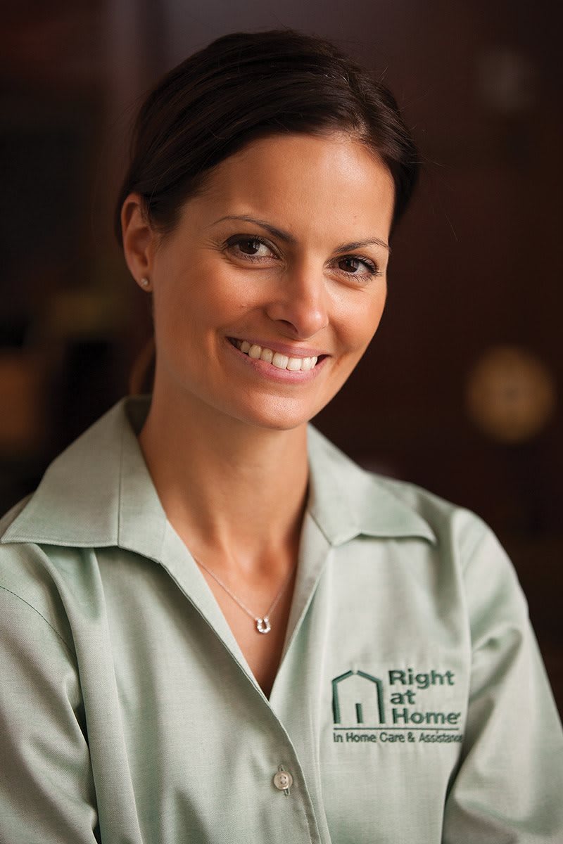 A professional woman smiling in a uniform indoors.