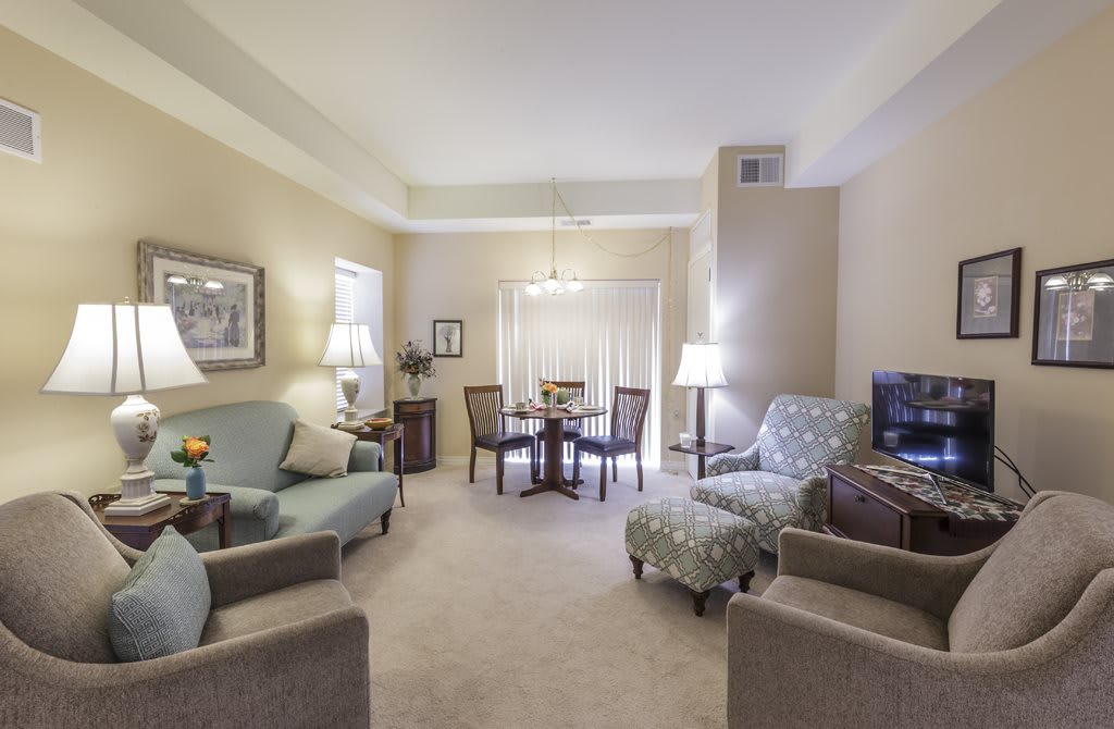 A cozy living room with a connected dining area featuring comfortable seating and warm lighting.
