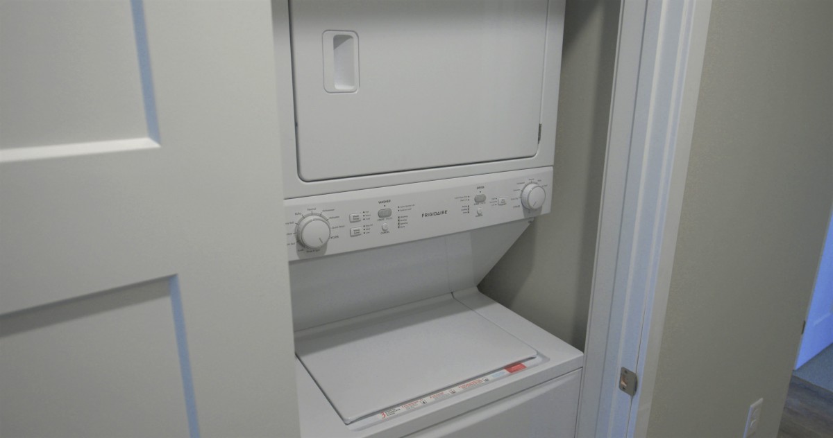 A stacked washer and dryer unit in a laundry area.