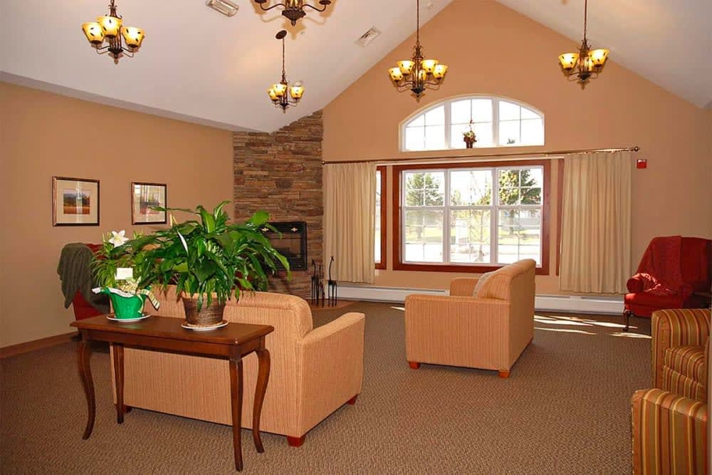 A cozy living room with sofas, a fireplace, and large windows.