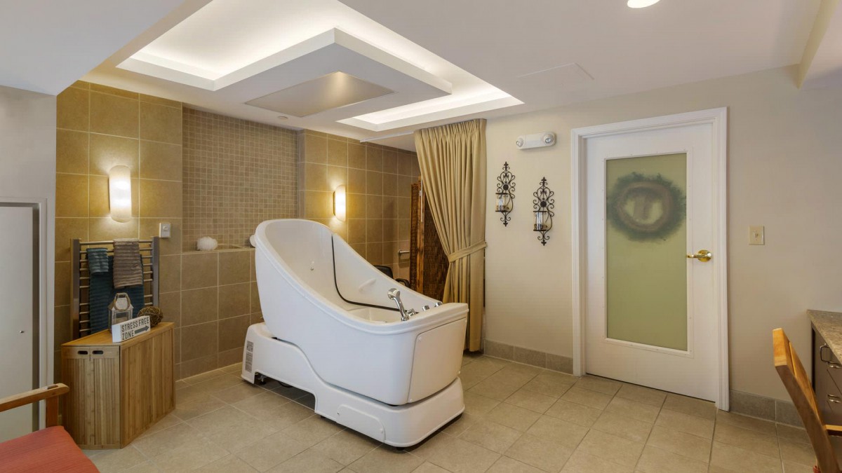 A modern spa therapy room featuring a unique wellness chair.