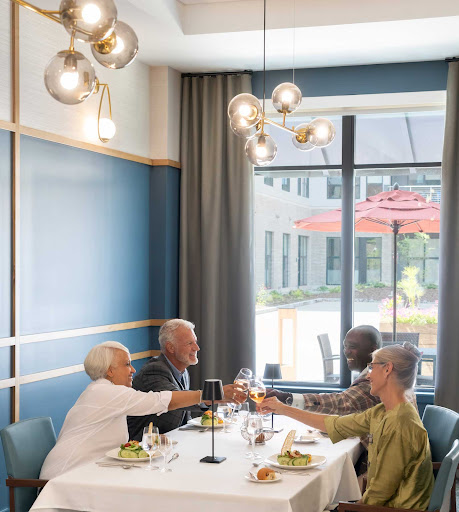 A joyful gathering of friends enjoying a meal together, raising their glasses in celebration.