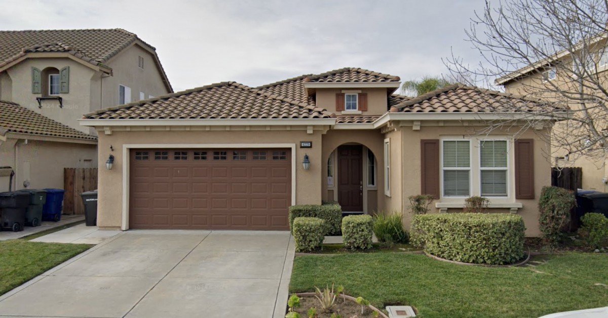 A suburban residential house with a tiled roof and attached garage.