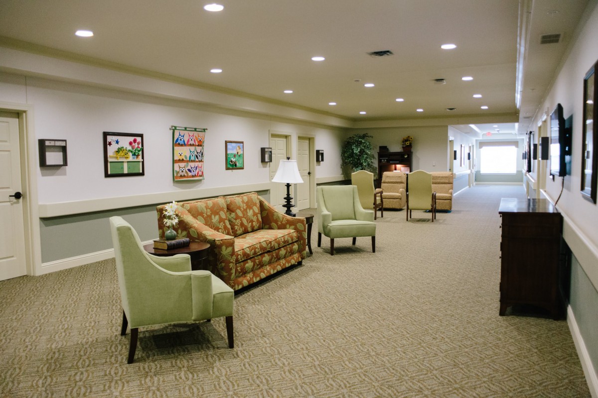A well-lit hallway with seating and artwork on the walls.
