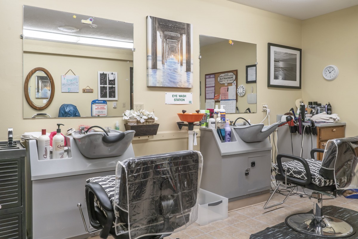 A clean and organized hair salon interior with washing stations and mirrors.