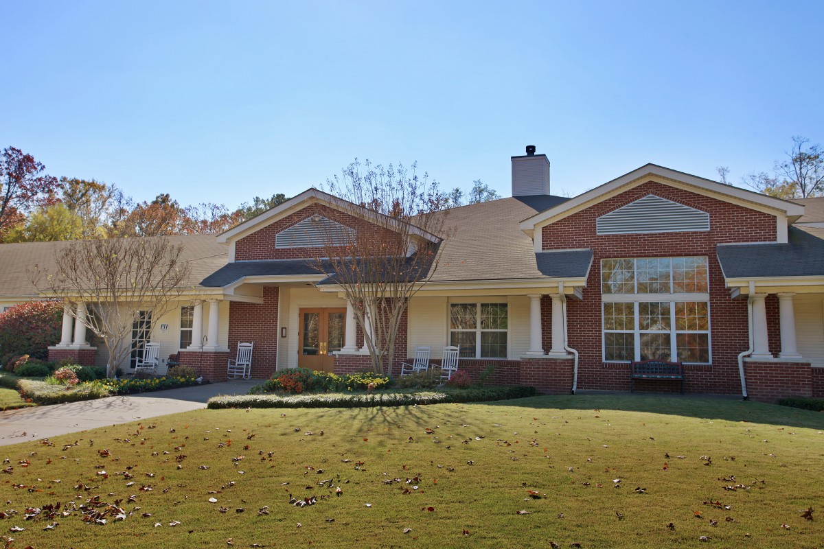A suburban house with a well-maintained lawn under a clear blue sky.