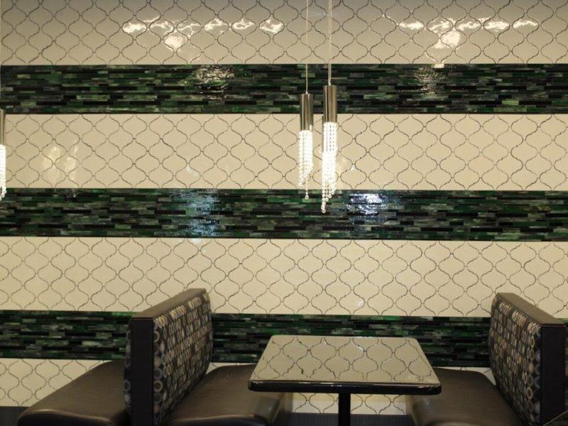 A modern restaurant booth with stylish lighting and tiled walls.