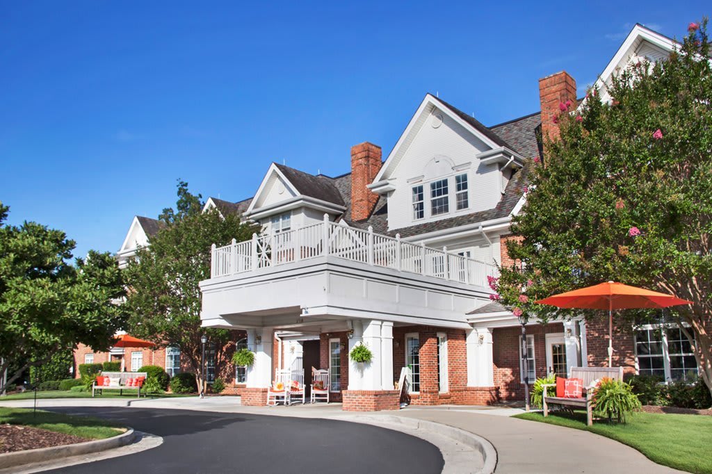 A large, suburban-style residential building with a porch and brick details.