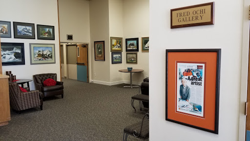 A cozy waiting area featuring several pieces of artwork on the walls.