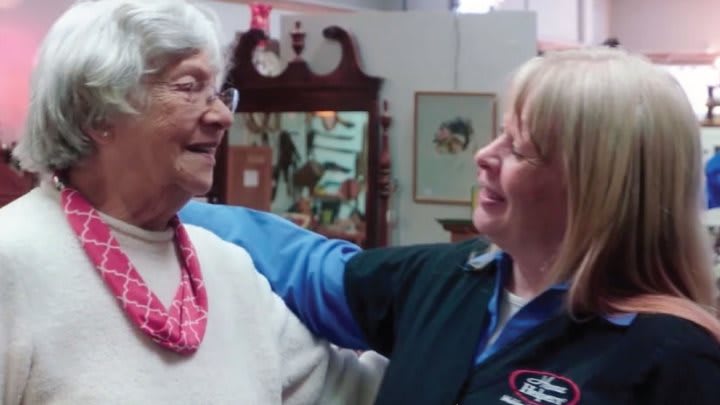 Two women share a moment of warmth and connection indoors.