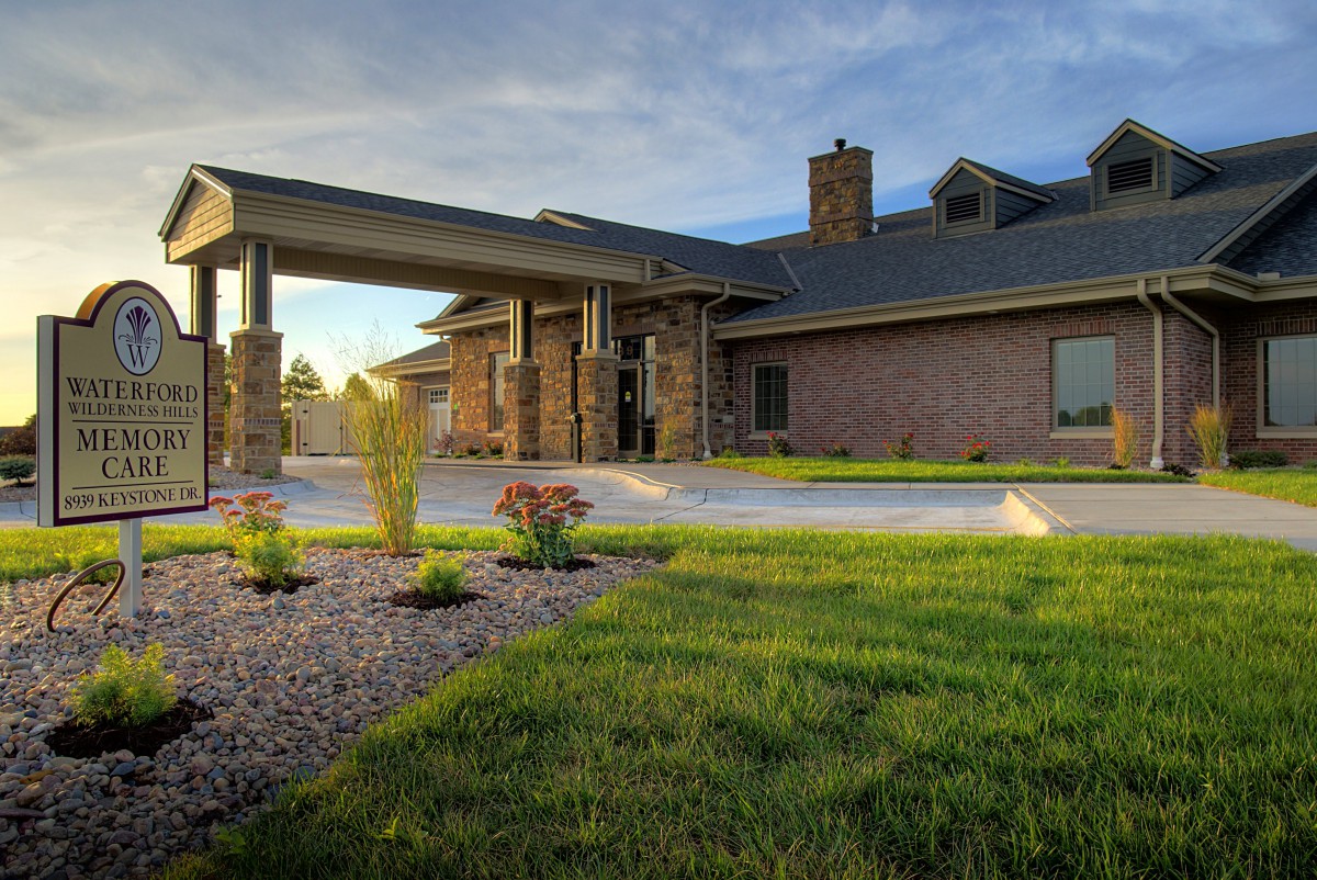 A modern brick house with well-maintained landscaping and a driveway.