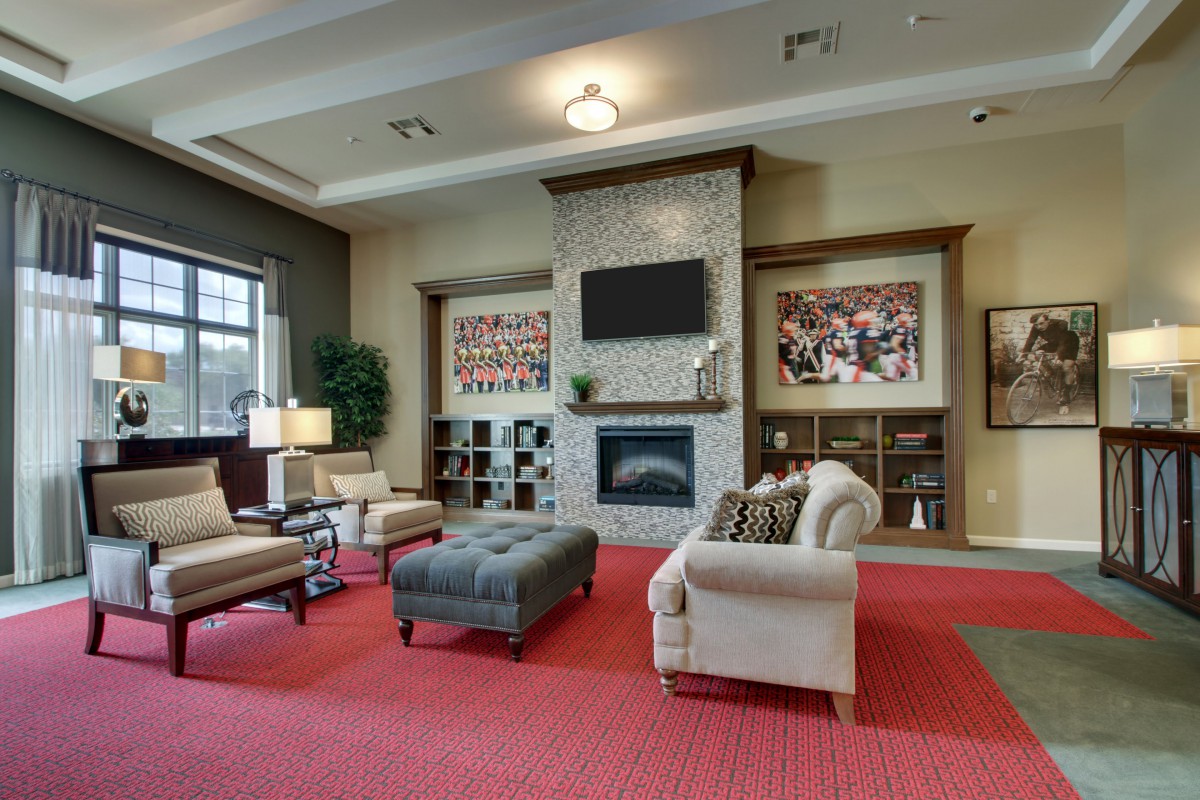 A cozy living room with a modern fireplace, comfortable seating, and decorative artwork.