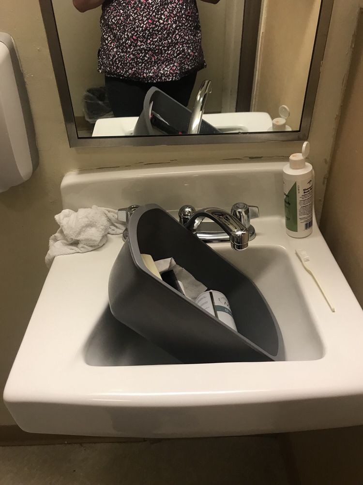 A urinal placed inside a bathroom sink, reflecting an unconventional setup.