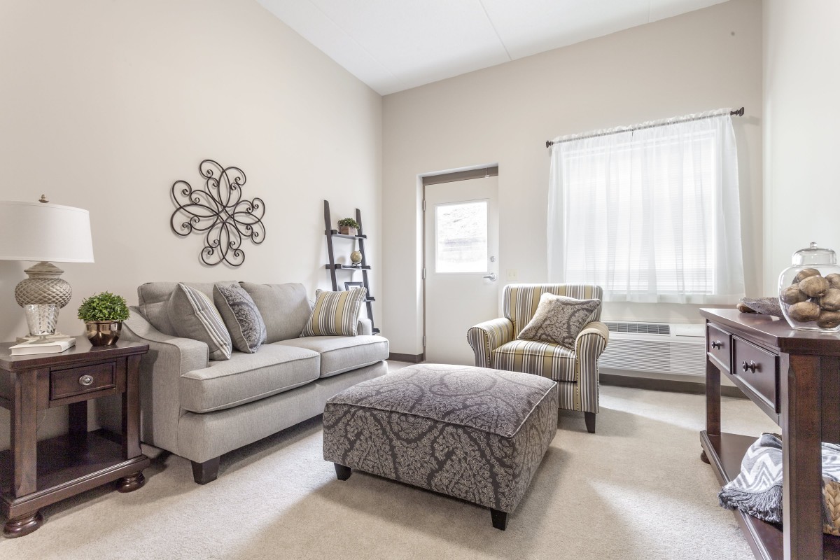 A modern living room with neutral-colored furniture and stylish decor.