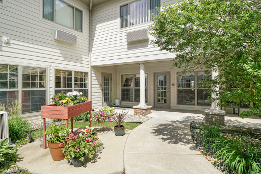 A beautifully landscaped courtyard featuring vibrant flowers and plants, surrounded by modern residential buildings.