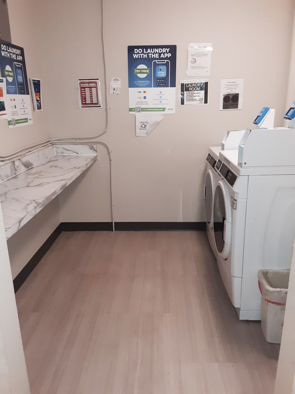 A clean and organized laundry room featuring a washer, dryer, and folding counter.
