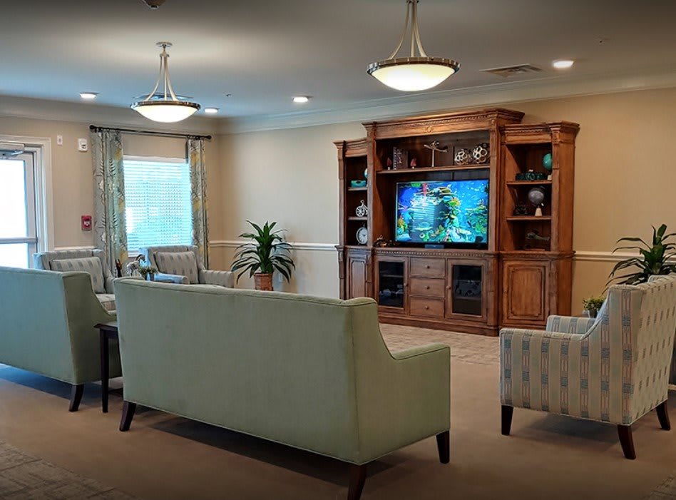 A cozy living room with a large sofa, entertainment center, and elegant lighting.