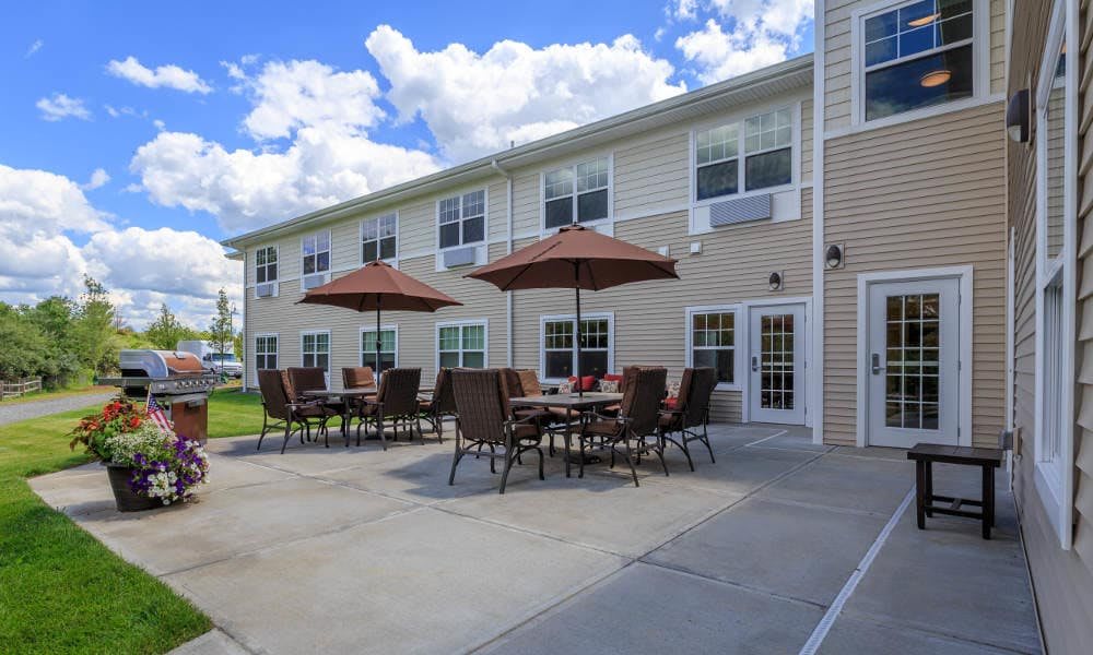 Outdoor patio area with tables and umbrellas at a residential building.