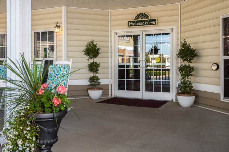 A welcoming entrance with potted plants and a 'Welcome Home' sign.