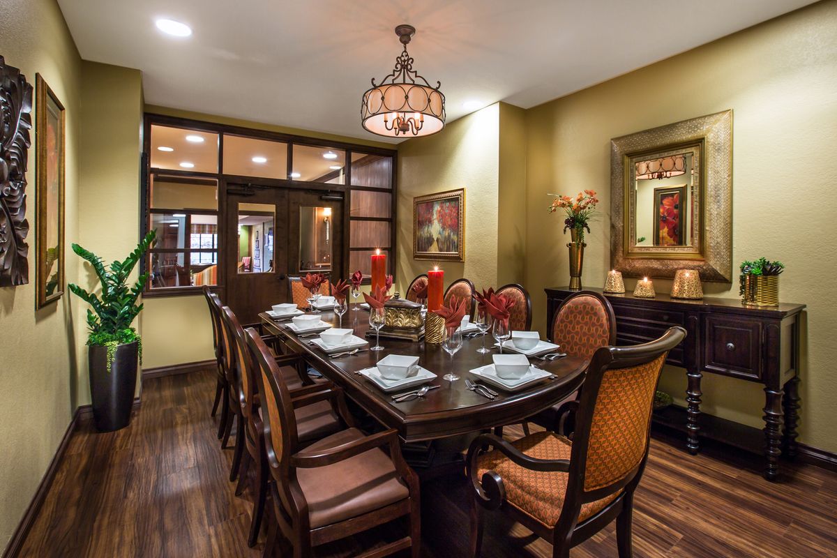 An elegantly set dining room with a luxurious table and chandelier.