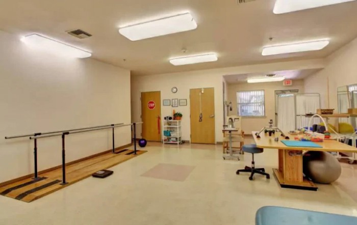 A rehabilitation room equipped with therapy tools and exercise equipment.