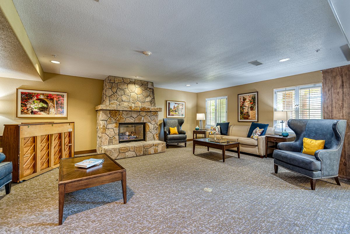 A cozy living room with a stone fireplace, comfortable seating, and tasteful decor.