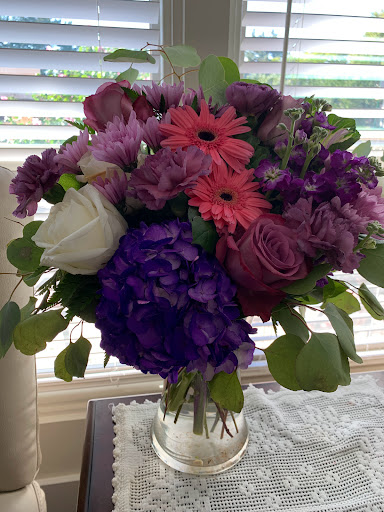 A vibrant bouquet featuring a mix of purple, pink, and white flowers, perfect for brightening any space.