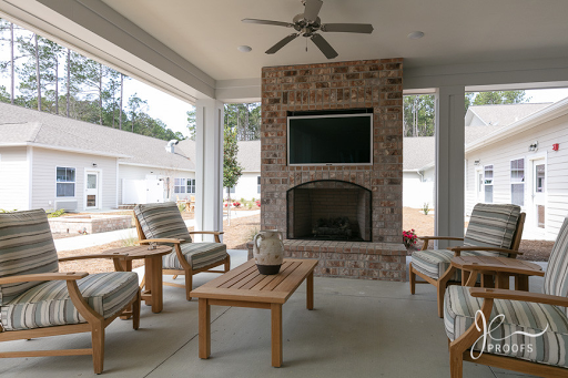 A cozy outdoor living space featuring a stone fireplace and comfortable seating.