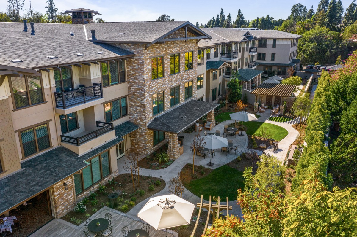 A view of a modern residential building with balconies and a landscaped courtyard.