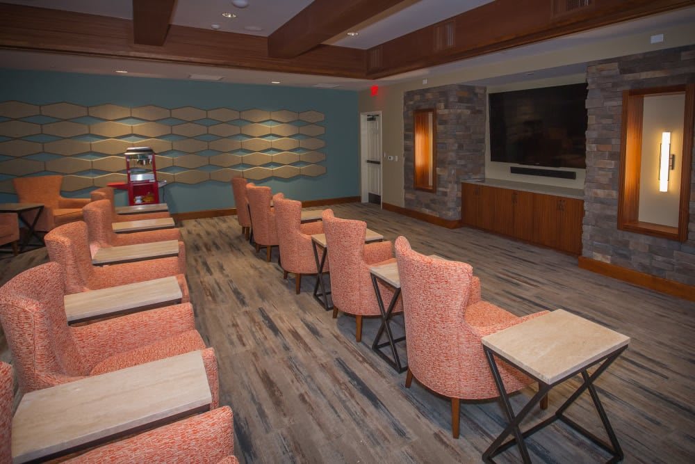 A modern indoor theater room with comfortable seating and a large screen.