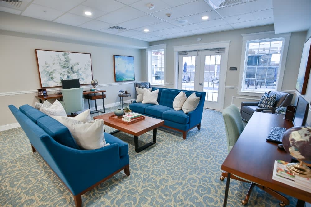 A modern living room with blue sofas and elegant decor.