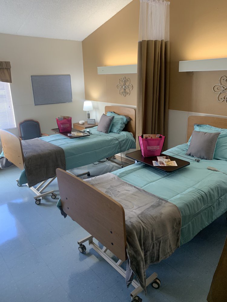 A clean and well-organized hospital room with two beds prepared for patients.