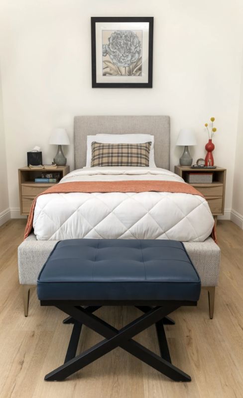 A neatly arranged bedroom with a single bed, two nightstands, and a bench at the foot of the bed.