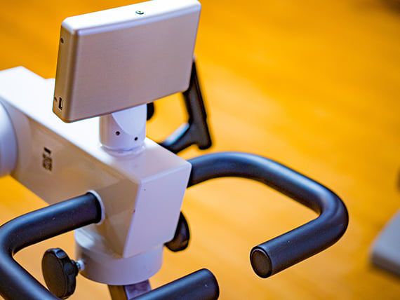 Close-up view of exercise bike handlebars with a display screen.